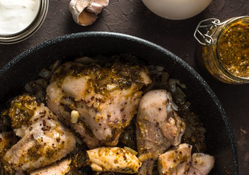 Fried pieces of chicken in a frying pan view from above. Indian food vertical